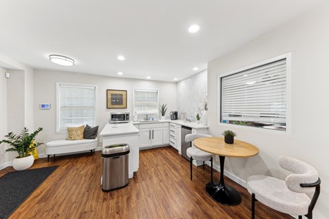 a living room with a kitchen and a table and chairs